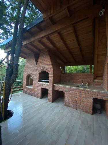 an outdoor kitchen with a brick oven on a patio at Villa Mali Stanishor in Novoberdo