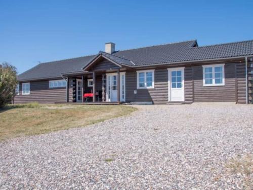 a house with a gravel driveway in front of it at Luxury Lodge with Limfjord View - By Traum Ferienwohnungen in Spottrup