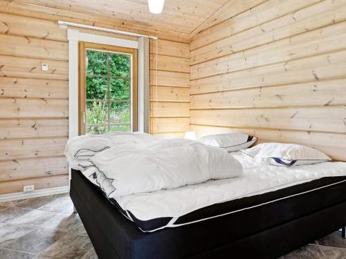 a bed in a room with a wooden wall at 5 star holiday home in Hadsund in Hadsund