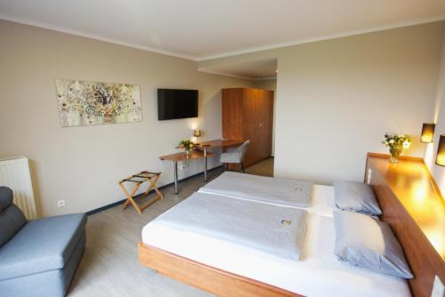 a bedroom with a large bed and a couch at Hotel Viva Bröckel in Bröckel