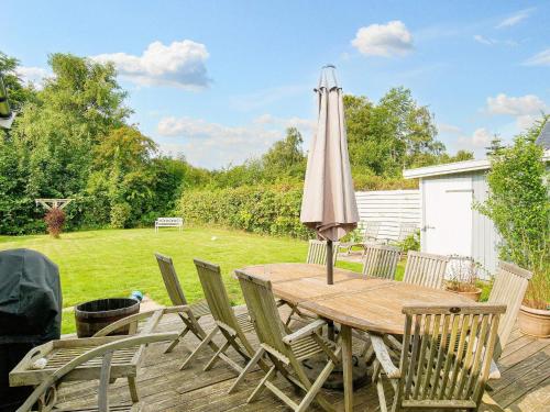 a wooden table with an umbrella on a deck at 10 person holiday home in Græsted-By Traum in Græsted