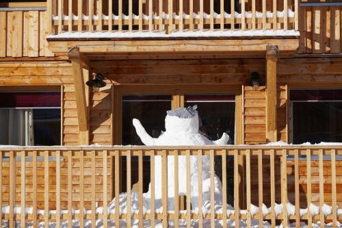 a snow man sitting on a porch of a building at Luxus Chalet Murmeltierhütte in Hohentauern