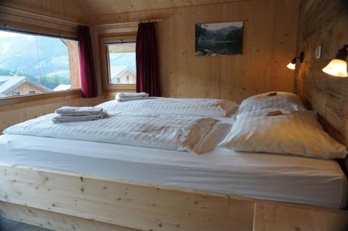 a bed in a wooden room with two pillows on it at Luxus Chalet Murmeltierhütte in Hohentauern