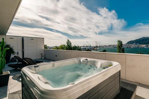 a bath tub sitting on top of a balcony at River Town View - Luxury Apartment with Jacuzzi on Terrace in Viana do Castelo