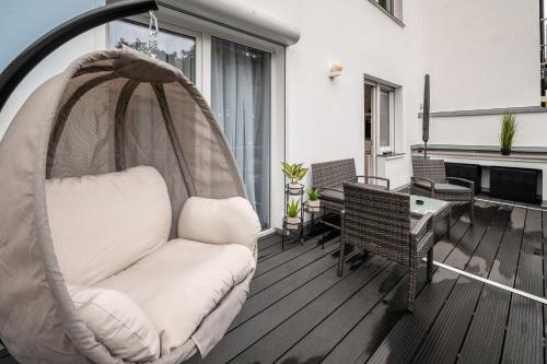 a hammock on a balcony with a table and chairs at Traumhaftes Apartment -Balkon -Hängesessel -WiFi in Viersen