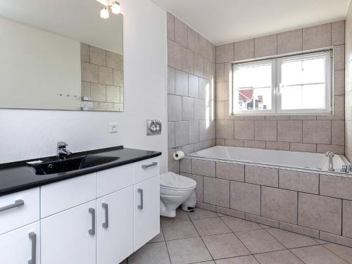 Un baño con bañera, lavabo e inodoro. en 8 person holiday home on a holiday park in Bogense, en Bogense