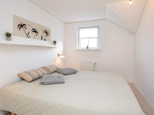Un dormitorio blanco con una cama grande con dos almohadas. en 8 person holiday home on a holiday park in Bogense, en Bogense