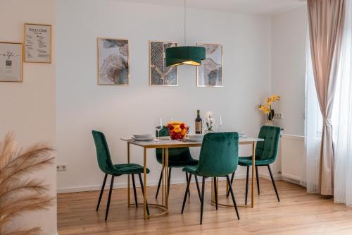 a dining room with a table and green chairs at Traumhaftes Apartment -Balkon -Hängesessel -WiFi in Viersen