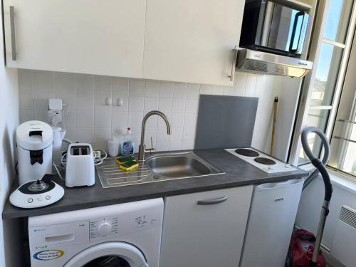 une cuisine avec un évier et une machine à laver dans l'établissement LE 10, Parking, Centre Confort, à Châteauroux