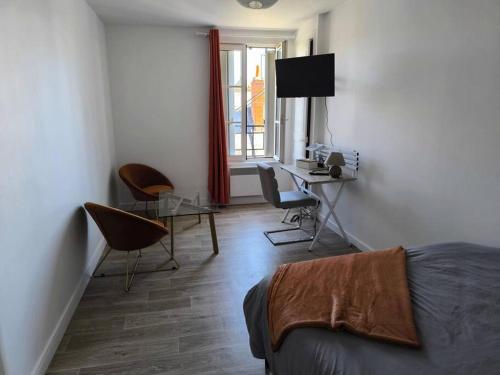 une chambre avec un lit, un bureau et une table dans l'établissement LE 10, Parking, Centre Confort, à Châteauroux