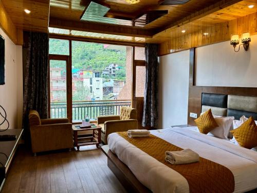 a bedroom with a large bed and a large window at Hotel Jogini Height's - Chandra A S Hospitality in Vashisht