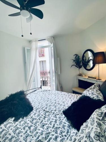 une chambre avec un lit avec un ventilateur de plafond dans l'établissement Le Chic-Cadre Royal-Centre ville, à Sète