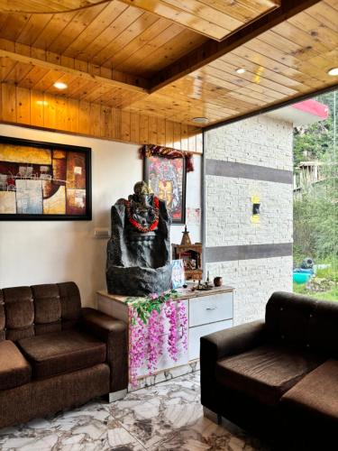 a living room with a couch and a table at Hotel Jogini Height's - Chandra A S Hospitality in Vashisht