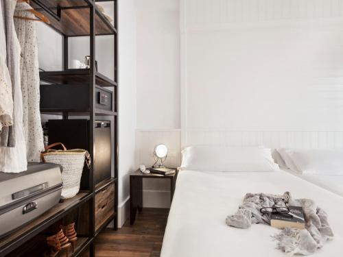 a bedroom with a bed with a book on it at Delamar 4*Sup-Adults only (18+) in Lloret de Mar