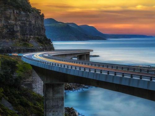 a bridge over a body of water with at Stunning Coastal Home Views 1 Hour From Sydney in Wombarra