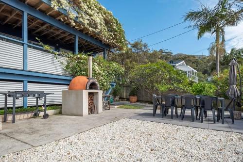 a patio with a table and chairs and an outdoor grill at Stunning Coastal Home Views 1 Hour From Sydney in Wombarra