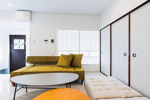 a living room with a couch and a table at Villa Myoden in Ichikawa