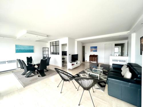 un salon avec un canapé, des chaises et une table dans l'établissement Appartement Alexandre lumineux avec superbe vue mer, à Cannes
