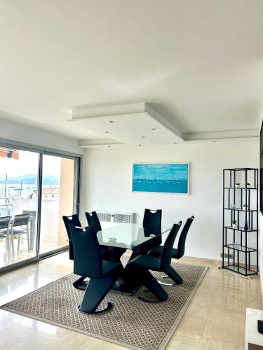une salle à manger avec une table et des chaises blanches dans l'établissement Appartement Alexandre lumineux avec superbe vue mer, à Cannes