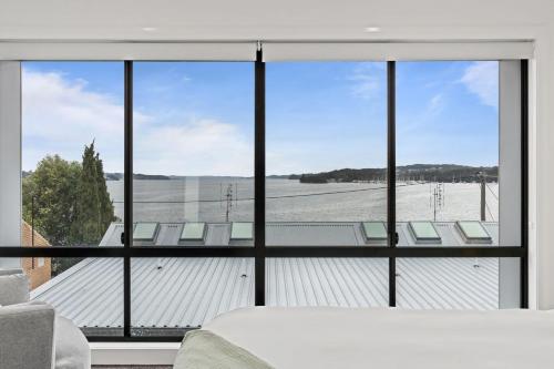 a bedroom with a large window with a view at Lakeview Luxury Work from home spaces in Warners Bay