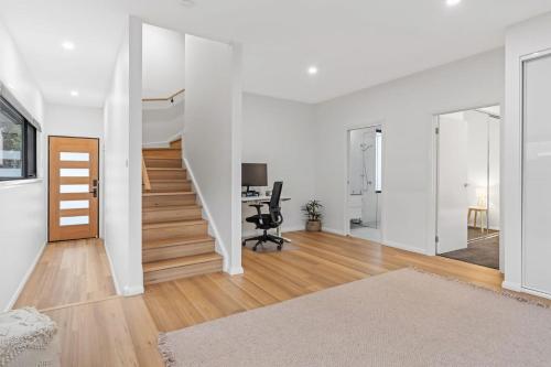 an open living room with white walls and wooden floors at Lakeview Luxury Work from home spaces in Warners Bay