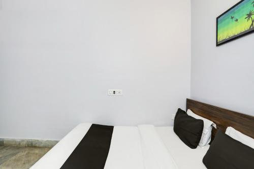 a bedroom with a bed and a tv on the wall at Hotel O Shree Ram Residency in Cuttack