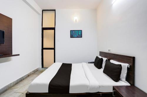 a bedroom with a black and white bed and a tv at Hotel O Shree Ram Residency in Cuttack