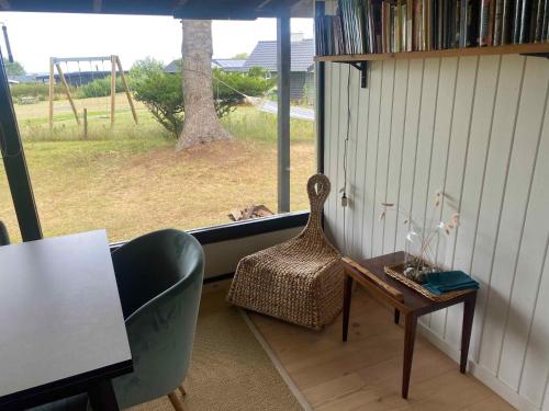 a room with a chair and a table and a window at Charming Nykøbing Sjælland Summerhouse in Nykøbing Sjælland