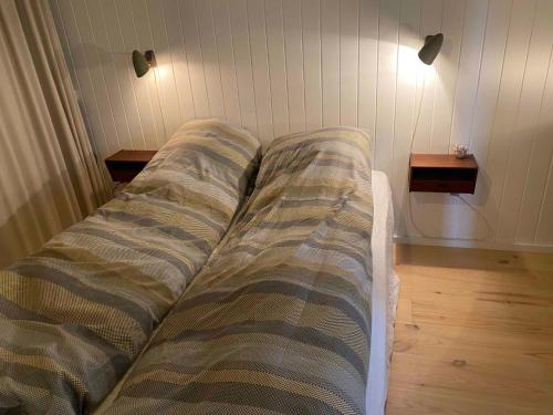 a unmade bed in a room with two side tables at Charming Nykøbing Sjælland Summerhouse in Nykøbing Sjælland