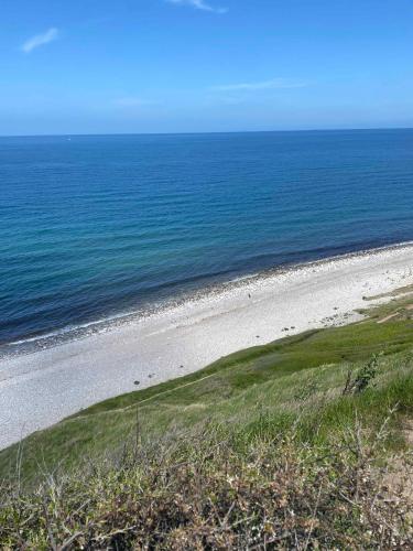 an empty beach with the ocean in the background at Charming Nykøbing Sjælland Summerhouse in Nykøbing Sjælland