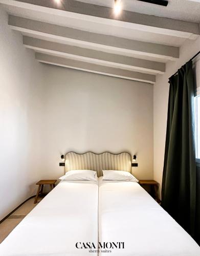 a bedroom with a white bed and a window at Casa Monti - Sherry Suites A in Jerez de la Frontera