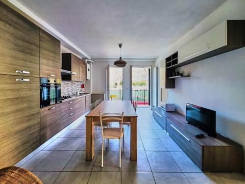 a kitchen with a wooden table and a television at Affitti Brevi Liguria - Casamare in Varazze