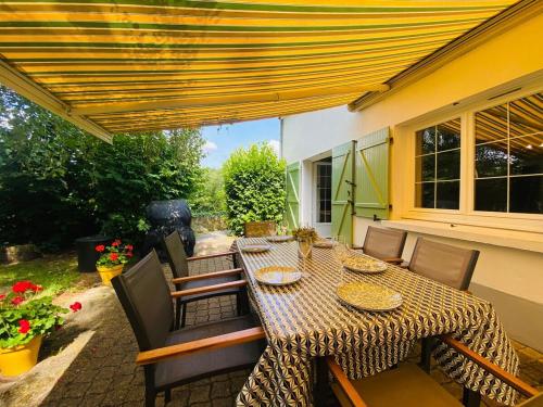 d'une terrasse avec une table et des chaises à baldaquin jaune. dans l'établissement Casa Rivage, à Chalonnes-sur-Loire