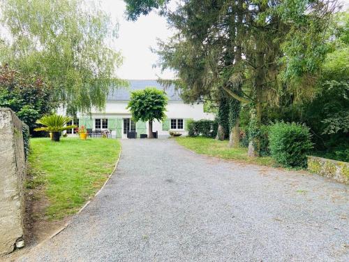 une allée menant à une maison blanche avec des arbres dans l'établissement Casa Rivage, à Chalonnes-sur-Loire