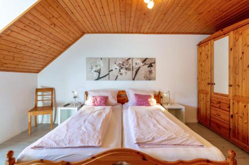 a bedroom with a large bed with a wooden ceiling at Haus Am Bühl in Schönau im Schwarzwald