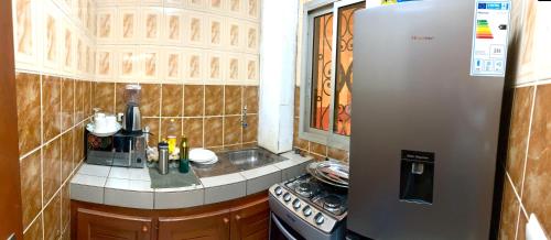 a small kitchen with a stainless steel refrigerator at Big apartment Yaoundé 2 rooms in Yaoundé