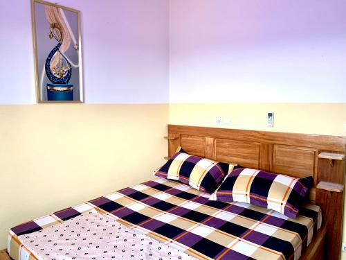 a bed with two pillows and a picture on the wall at Big apartment Yaoundé 2 rooms in Yaoundé