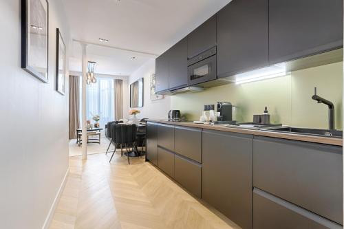 une cuisine avec des armoires noires et une salle à manger dans l'établissement Stylish 2 Bedroom near Montmartre Sacré Cœur, à Paris
