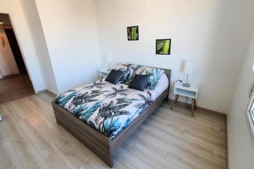 Un dormitorio con una cama y una mesa con una lámpara. en Orly Express - Confort à Deux Pas de l'Aéroport, en Orly