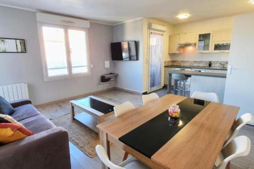 Una sala de estar con una mesa de madera y un sofá. en Orly Express - Confort à Deux Pas de l'Aéroport, en Orly