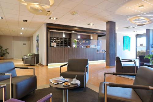 a waiting room with chairs and a table at Résidence Les Calanques in Ajaccio