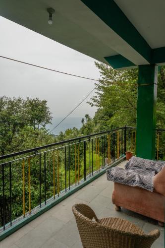 un balcón de una casa con vistas a los árboles en Vibe Hostel, en Dharamshala