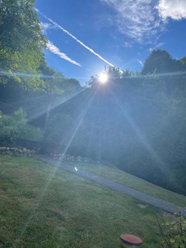 a sun shining on a field with the grass at DeNi's Ferienwohnungen in Klotten