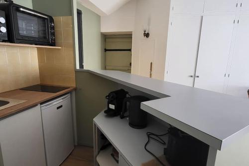 - une cuisine avec un comptoir et un four micro-ondes dans l'établissement studio situé entre port et plage, à Les Sables-dʼOlonne