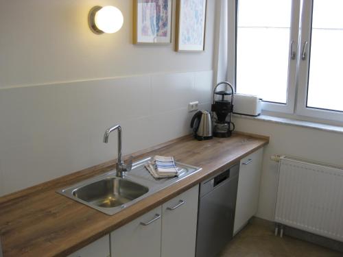 eine Küchentheke mit einem Waschbecken und einem Fenster in der Unterkunft Ferienwohnungen Familie Böckmann in Berlin