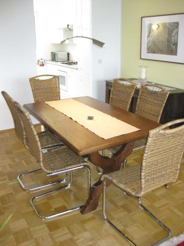 a dining room table with wicker chairs around it at Ferienwohnungen Familie Böckmann in Berlin