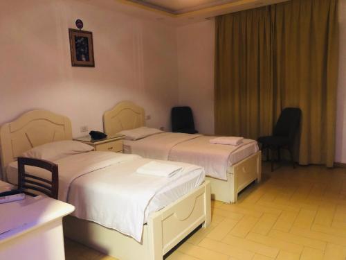 a hotel room with two beds and two chairs at فندق اربد بلازا in Irbid