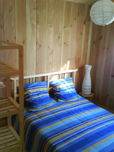 - une chambre avec un lit doté de draps bleus et d'une lampe dans l'établissement Maison quatre voyageurs, à Maubuisson