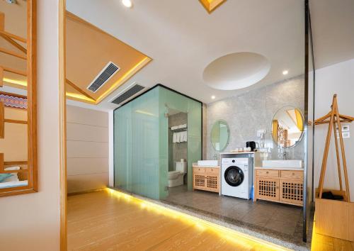 a bathroom with a washer and dryer in a room at Zhangjiajie DreamWay Hotel - Free pick up service in Zhangjiajie