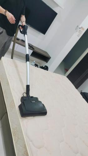 a person using a mop on a table at Nyaman Sweet Home in Balik Pulau